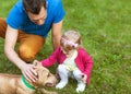 Happy family playing in the park with his dog Royalty Free Stock Photo