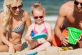 Happy family playing with sand toys on beach