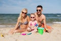 Happy family playing with sand toys on beach