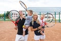 Happy family playing tennis holding rackets at the court Royalty Free Stock Photo