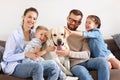 Happy family playing with their favorite pet dog   at home Royalty Free Stock Photo