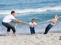 Happy family playing tug of war Royalty Free Stock Photo