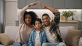 Happy family portrait African American loving ethnic couple woman man join hands showing roof over heads gesture adopted