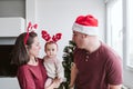 Happy family portrait with baby girl playing at home with reindeer diadem. Christmas concept