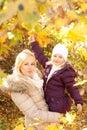 Happy family portrait, blonde mother and her daughter in autumn park Royalty Free Stock Photo