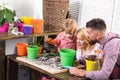 Happy family portrait having fun together. Father mother and child son growing plant in pot. Little cute boy helps his