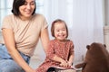 Happy family portrait of mother with daughter with down syndrome at home with toys