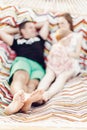 Happy family portrait, young hipster father and mother lying in a hammock with their baby daughter, focus on feet, blurred Royalty Free Stock Photo