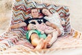 Happy family portrait, young hipster father and mother lying in a hammock with their baby daughter, summer vacation family trip Royalty Free Stock Photo