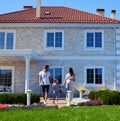 Happy family posing in front of new modern house Royalty Free Stock Photo