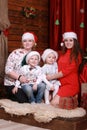 Happy family posing for photo at christmas. grandmother and mother with two children in santa hats