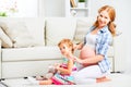Happy family pregnant mother combing hair of little daughter Royalty Free Stock Photo