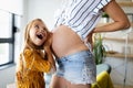 Happy family. Pregnant mother and daughter kissing relaxing at home Royalty Free Stock Photo