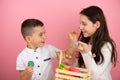 Happy family preparing for Easter, cute brother holding a green egg in his hand and using a brush painting his sister Royalty Free Stock Photo