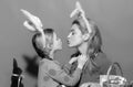 Happy family preparing for Easter. Cute little child girl and mom wearing bunny ears. Mother and daughter kiss. Royalty Free Stock Photo