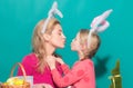 Happy family preparing for Easter. Cute little child girl and mom wearing bunny ears. Mother and daughter kiss. Royalty Free Stock Photo