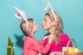 Happy family preparing for Easter. Cute little child girl and mom wearing bunny ears. Mother and daughter kiss. Royalty Free Stock Photo