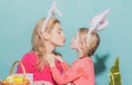 Happy family preparing for Easter. Cute little child girl and mom wearing bunny ears. Mother and daughter kiss. Royalty Free Stock Photo