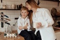 Happy family preparing Easter eggs indoors. Mother and boy celebrating happy Easter holiday together at home Royalty Free Stock Photo