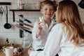 Happy family preparing Easter eggs indoors. Mother and boy celebrating happy Easter holiday together at home Royalty Free Stock Photo