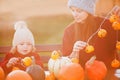 Mother and child choosing pumpkins for jack-o-lantern.