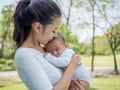 Happy family, Pretty woman holding a newborn baby in her arms on nature park in summer Royalty Free Stock Photo