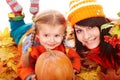 Happy family with pumpkin on autumn leaves. Royalty Free Stock Photo