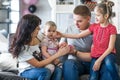 Happy family with puppies of English bulldog on his hands sitting on the couch Royalty Free Stock Photo