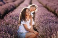 Happy family in purple lavender field. young beautiful mother and child Girl enjoy walking blooming meadow on summer day Royalty Free Stock Photo