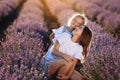Happy family in purple lavender field. young beautiful mother and child Girl enjoy walking blooming meadow on summer day Royalty Free Stock Photo