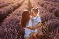 Happy family in purple lavender field. young beautiful mother and child Girl enjoy walking blooming meadow on summer day Royalty Free Stock Photo