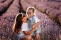 Happy family in purple lavender field. young beautiful mother and child Girl enjoy walking blooming meadow on summer day Royalty Free Stock Photo