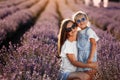 Happy family in purple lavender field. young beautiful mother and child Girl enjoy walking blooming meadow on summer day Royalty Free Stock Photo