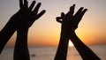 Happy family raising hands up. Hands up in the air silhouette over sunset sky. Royalty Free Stock Photo