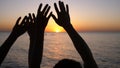 Happy family raising hands up. Hands up in the air silhouette over sunset sky. Royalty Free Stock Photo