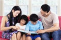 Happy family read story book on sofa