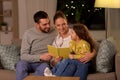 Happy family reading book at home at night Royalty Free Stock Photo