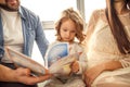 Happy family reading a book to her daughter. Mothers Day Royalty Free Stock Photo