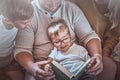 Happy family reading a book together in warm living room Royalty Free Stock Photo