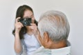 Happy family relationship, Asian daughter taking photo of old elderly father to keep good memory. Royalty Free Stock Photo