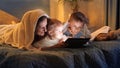 Happy family relaxing in bed with tablet computer. Family having time together, parenting, happy childhood and entertainment Royalty Free Stock Photo