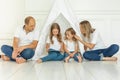 Happy family relaxing with a digital tablet sitting on floor, watching video, playing game on the touchscreen, have fun together Royalty Free Stock Photo