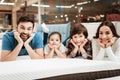 Happy family is relaxing on mattress in orthopedic furniture store. Big family together check softness of mattress Royalty Free Stock Photo