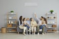 Happy family sitting together on a couch at home under a new modern air conditioner Royalty Free Stock Photo