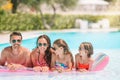 Happy family of four in outdoors swimming pool Royalty Free Stock Photo