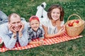 Happy family resting in nature. Mother, father and child Enjoying and lying on checkered plaid in meadow