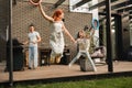 A happy family is resting not far from their home. dad is cooking a barbecue, and mom and daughter are playing jumping Royalty Free Stock Photo