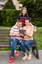 Happy family resting in the park and using tablet PC outdoors Royalty Free Stock Photo