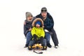 Happy family rides the sledge in winter. Winter vacation. Family having fun together in winter resort in mountain Royalty Free Stock Photo