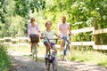 Happy family riding bicycles in summer park